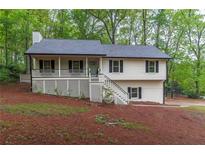 Charming two-story home featuring a cozy front porch and well-maintained landscaping at 607 Hickory Creek Ln, Woodstock, GA 30188