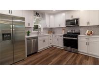 Well-lit kitchen featuring stainless steel appliances and white cabinets at 607 Hickory Creek Ln, Woodstock, GA 30188