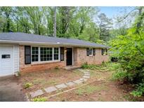 Charming brick home with black shutters, a stone path, and a lovely front yard at 980 Oakton Sw Dr, Marietta, GA 30060