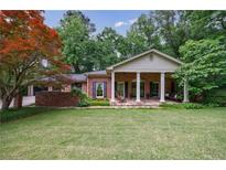 Charming brick home features a columned front porch and lush green lawn at 4311 N Elizabeth Se Ln, Atlanta, GA 30339
