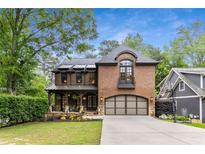 Charming brick home featuring a two-car garage, covered porch, and manicured landscaping at 2871 Parkridge Ne, Brookhaven, GA 30319