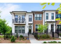 Attractive townhome with a painted brick facade, upper balcony and front yard landscaping at 300 Olmstead Way, Alpharetta, GA 30022