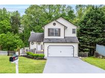 Charming two-story home featuring a well-manicured lawn and a two-car garage at 1029 Megan Ct, Sugar Hill, GA 30518