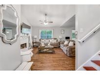 Cozy living room features hardwood floors, large window, and comfortable seating arrangements at 1029 Megan Ct, Sugar Hill, GA 30518