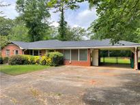Charming single-story brick home featuring a covered carport and mature landscaping at 2988 Ramble Ln, Decatur, GA 30033