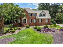 Charming two-story brick home with a well-manicured lawn and colorful landscaping at 1885 Vintage Dr, Snellville, GA 30078