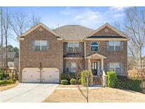 Beautiful two-story brick home with a two-car garage, landscaped yard, and inviting front entrance at 4058 Rosebay Way, Conyers, GA 30094