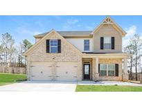 Charming two-story home featuring a brick and siding exterior, a two-car garage, and a manicured front lawn at 89 Citadel Dr, Hampton, GA 30228