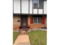 Charming brick home featuring a welcoming front door, red flower pots, and matching red shutters adding a touch of classic style at 1451 Wamsley Way, Stone Mountain, GA 30083