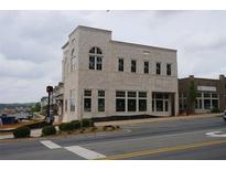 Modern building featuring multiple windows and an intricate brick pattern at 9244 Main Street # 102, Woodstock, GA 30188