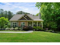 Charming home with stone accents, covered porch, and beautifully landscaped front yard and walkway at 33 Kay Ne Rd, White, GA 30184