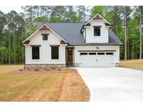 Charming new construction home featuring a white facade, a two-car garage, and a meticulously manicured lawn at 130 Doris Path, Dallas, GA 30157
