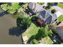 Stunning aerial view of a backyard and lake with a well-maintained lawn, deck, and mature trees at 2436 Camden Lake Nw Vw, Acworth, GA 30101