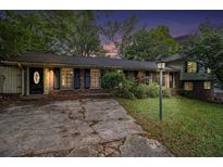 Charming brick home with a well-maintained front yard and classic black shutters at twilight at 3743 Tree Bark Trl, Decatur, GA 30034