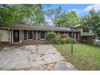 Ranch style home with brick facade, black shutters, and mature trees at 3743 Tree Bark Trl, Decatur, GA 30034