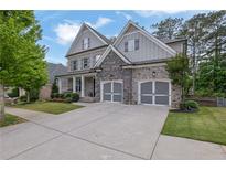 Beautiful home featuring a stone and siding exterior, complemented by a well-manicured lawn and a spacious driveway at 238 Harmony Lake Dr, Canton, GA 30115