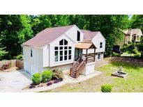 Charming home featuring large windows, a covered entry, landscaped yard, and a decorative fountain at 3748 Woodrose Ct, Snellville, GA 30039