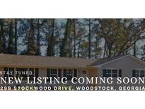 Charming single-story home with black shutters and a well-maintained lawn at 299 Stockwood Dr, Woodstock, GA 30188