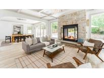 Spacious living room with stone fireplace, coffered ceilings, and an open dining area, perfect for modern living at 50 Dartmouth Ave, Avondale Estates, GA 30002