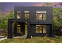 Modern two-story home features a black exterior, a bright yellow door, and many windows at 2402 Lynn Iris Dr, Decatur, GA 30032