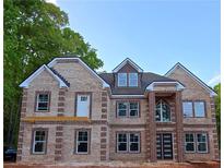 Stunning two-story brick home boasting grand entrance, dormer window, and expansive front windows at 1360 Dickens Nw Rd, Lilburn, GA 30047