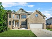 Charming brick two-story home featuring a well-manicured lawn and a two-car garage at 15 Manas Ct, Covington, GA 30016