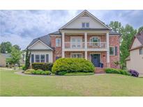 Charming two-story brick home with a covered porch and manicured lawn at 2112 Ivey Chase Dr, Dacula, GA 30019