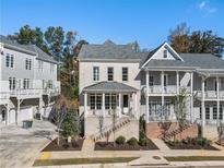 Charming townhome with brick facade, covered front porch, and well-maintained landscaping in a desirable neighborhood at 2035 Parkside Ln, Roswell, GA 30076