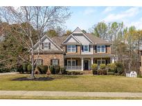 Traditional two-story brick home with a well-manicured lawn, covered porch, and inviting curb appeal at 2123 Indian Ivey Ln, Dacula, GA 30019