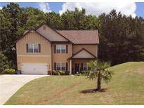 Charming two-story home featuring a well-manicured lawn and a driveway leading to an attached garage at 504 Liverpool Dr, Mcdonough, GA 30252