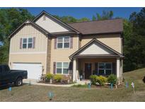Charming two-story home featuring a well-manicured lawn, complemented by decorative shrubs and tasteful landscaping at 504 Liverpool Dr, Mcdonough, GA 30252