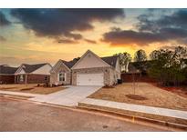 Charming single-story home featuring a two-car garage, a brick facade, and a well-manicured front yard at 853 Crossroads Ct, Social Circle, GA 30025