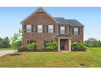 Two-story brick home with black shutters and a well-manicured lawn at 229 Prescott St, Locust Grove, GA 30248