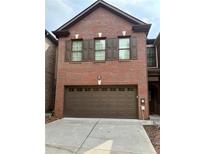 Two-story brick home with a brown garage door and matching shutters at 5872 Oakbrook Lake Ct, Norcross, GA 30093