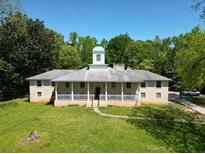 Charming home with a spacious front yard, covered porch, and architectural details at 11433 Panhandle Rd, Hampton, GA 30228