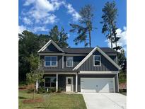 Charming two-story home featuring gray siding, white trim, a well-manicured lawn, and an attached two-car garage at 3036 Zodiac Ct, Lawrenceville, GA 30044