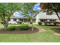 Charming white two-story home with lush landscaping and a well-manicured lawn at 1863 Trumbull Dr, Atlanta, GA 30338