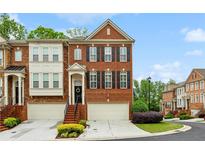Charming brick townhome with attached garages and inviting front entrances with manicured landscaping at 4888 Colchester Se Ct # 3, Atlanta, GA 30080