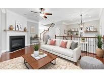 Bright living room with a cozy fireplace, modern ceiling fan, and beautiful staircase at 2313 Millhaven St, Smyrna, GA 30080