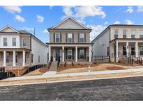 Charming two-story home featuring a covered porch, gray brick facade, and landscaped front yard at 173 Basil St, Cumming, GA 30040