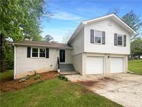 Charming two-story home with a white brick facade and a two-car garage and black shutters at 2067 Wellborn Close, Lithonia, GA 30058