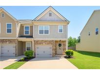 Charming two-story townhome features a brick facade, gray siding, manicured lawn and attached garage at 4925 Longview Walk, Decatur, GA 30035