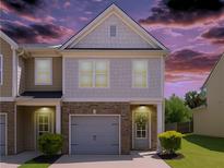 Charming townhome with brick accents, a gray garage door, well-manicured bushes, and inviting curb appeal at 4925 Longview Walk, Decatur, GA 30035