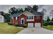 Charming two-story brick home with attached two-car garage and well-manicured front lawn at 3681 Auger Trl, Douglasville, GA 30135