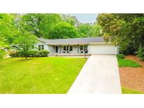 Charming single-story home featuring a well-manicured lawn and an attached two-car garage at 1662 Rainier Falls Ne Dr, Atlanta, GA 30329