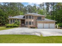 Stately brick home with a three-car garage and well-manicured landscaping provides elegant curb appeal at 5302 Greenway Dr, Villa Rica, GA 30180