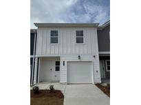 Charming two-story home with a one-car garage and vertical siding details at 9458 Pinecrest Path # 317, Jonesboro, GA 30238