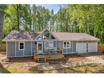 Charming home featuring a deck, two-car garage, and a welcoming front yard at 1660 Rose Garden Ln, Loganville, GA 30052