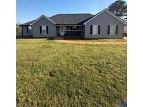 Charming one-story home with a well-maintained lawn, classic design, and a welcoming entrance with a covered porch at 237 Ferguson Ave, Locust Grove, GA 30248