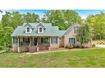 Charming brick home features a covered front porch, a metal roof, and a well-manicured front lawn at 4332 Brushy Mountain Rd, Rockmart, GA 30153
